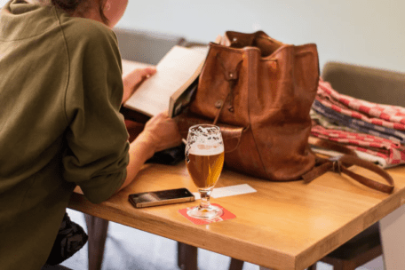 女人一边看书一边喝啤酒